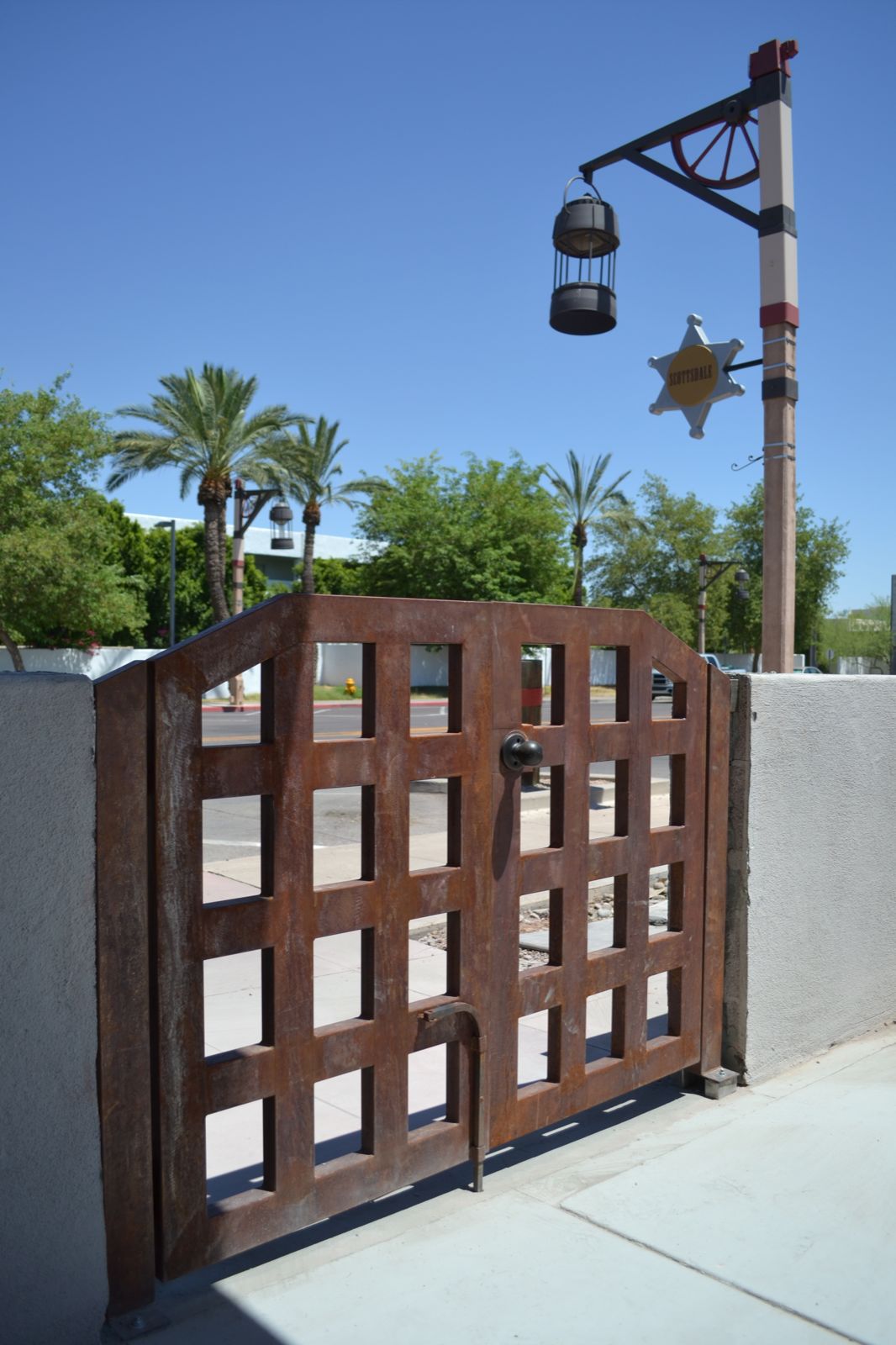 Picture of a rusty, raw steel double gate, constructed with 3" by 1.5" rectangular steel tubing welded to a grid with roughly 9" openings.